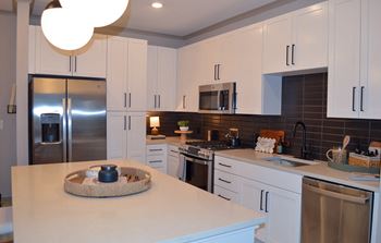 A kitchen with white cabinets and stainless steel appliances